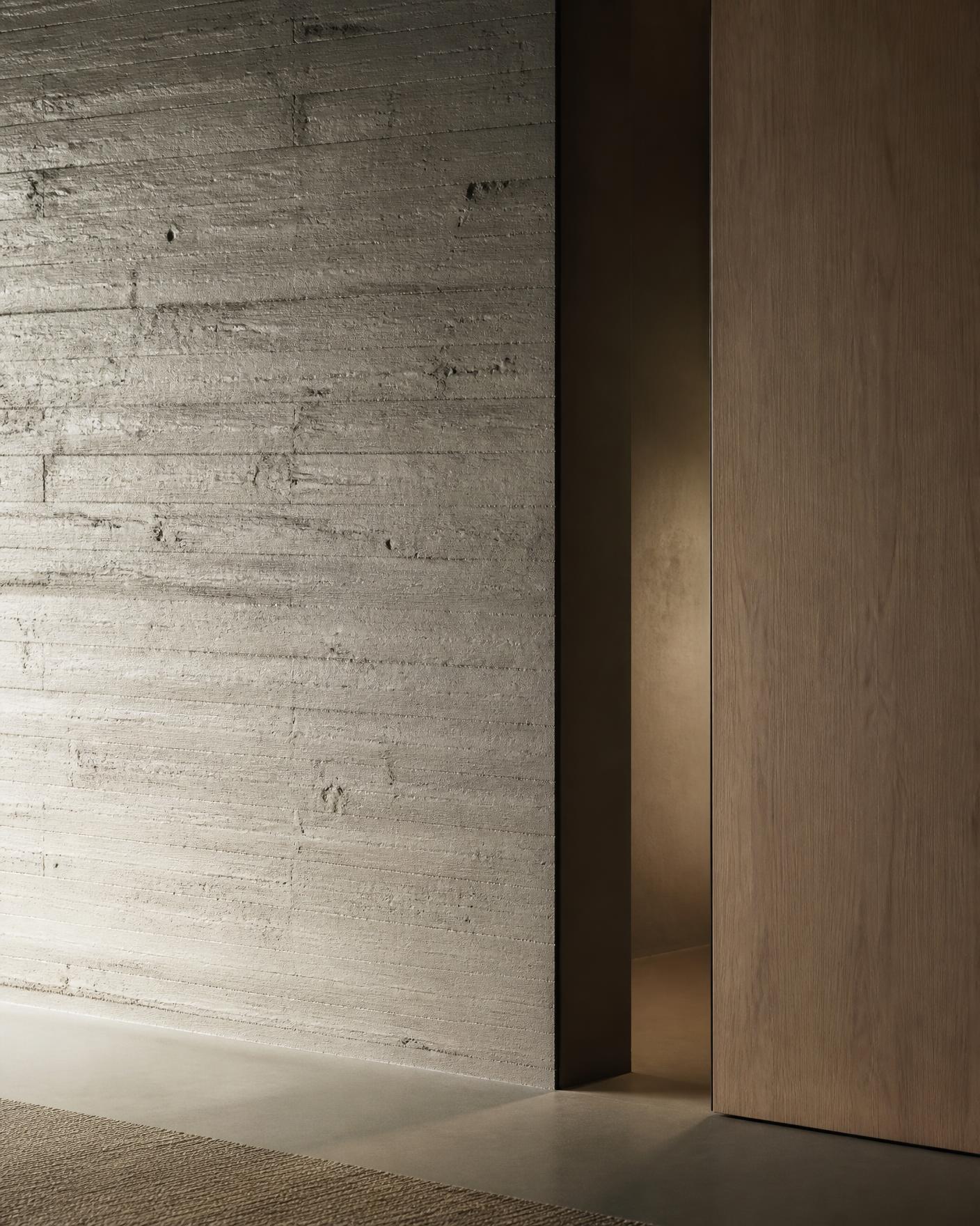 Board-marked concrete wall meeting a solid oak plane in grazing daylight